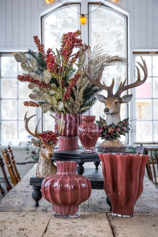 Dekorativ hjortbyst med stora horn, omgiven av röda blomsterarrangemang och keramikvas | A Lot Decoration | Lilla Hem