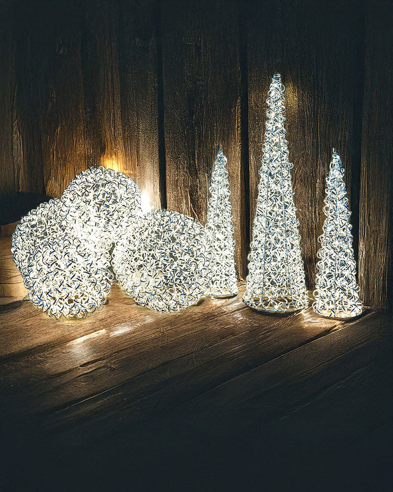 Belysningsdekorationer i olika former: två rundade LED-bollar och tre koniska LED-träd på trägolv | A Lot Decoration | Lilla Hem