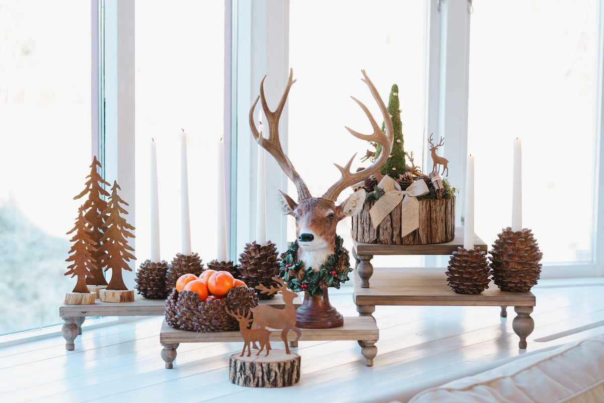 Ljusstake i form av tallkotte på träplintar, omgiven av höstdekoration med hjortar och ljus | A Lot Decoration | Lilla Hem