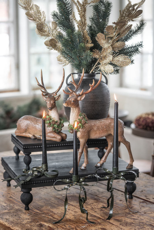 Liggande hjort i trä med dekorativ krans, placerad på svart metallbricka tillsammans med ljusstakar | A Lot Decoration | Lilla Hem