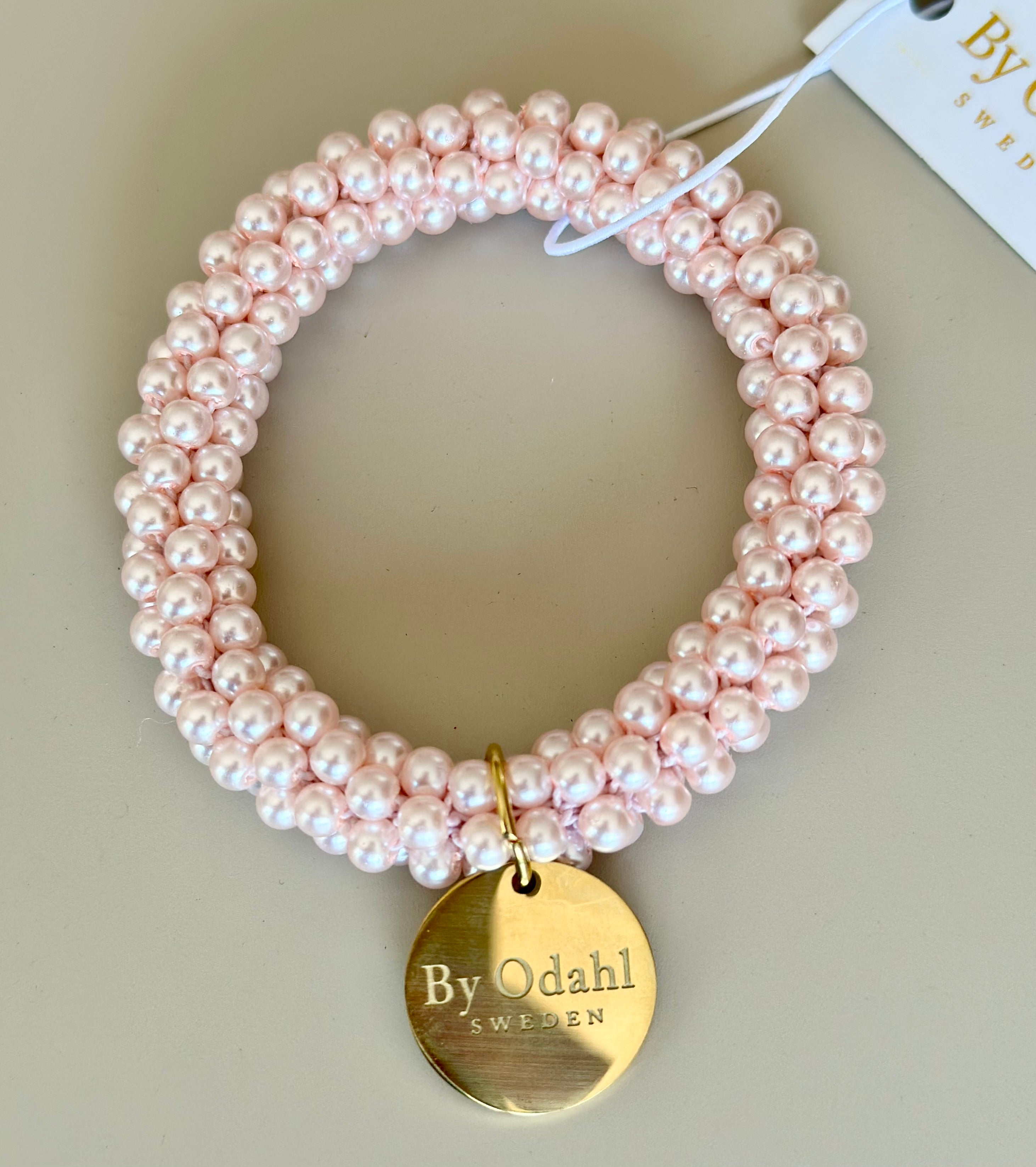 Armband med rosa pärlor i elastisk snodd och guldpläterad bricka, framifrån | By Odahl Sweden | Lilla Hem