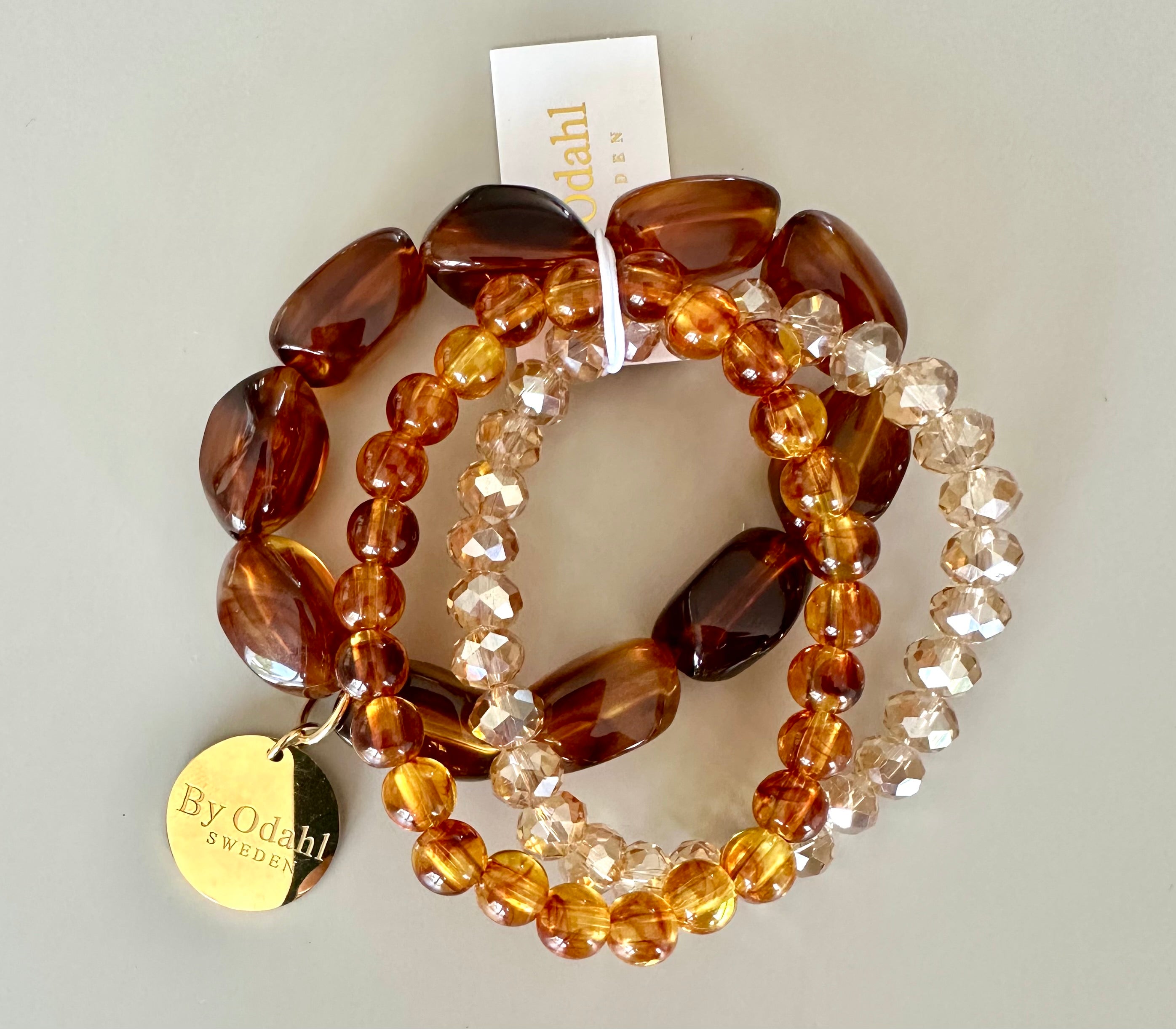 Tre armband med bruna och transparenta facetterade pärlor, visade platt mot vit bakgrund | By Odahl Sweden | Lilla Hem