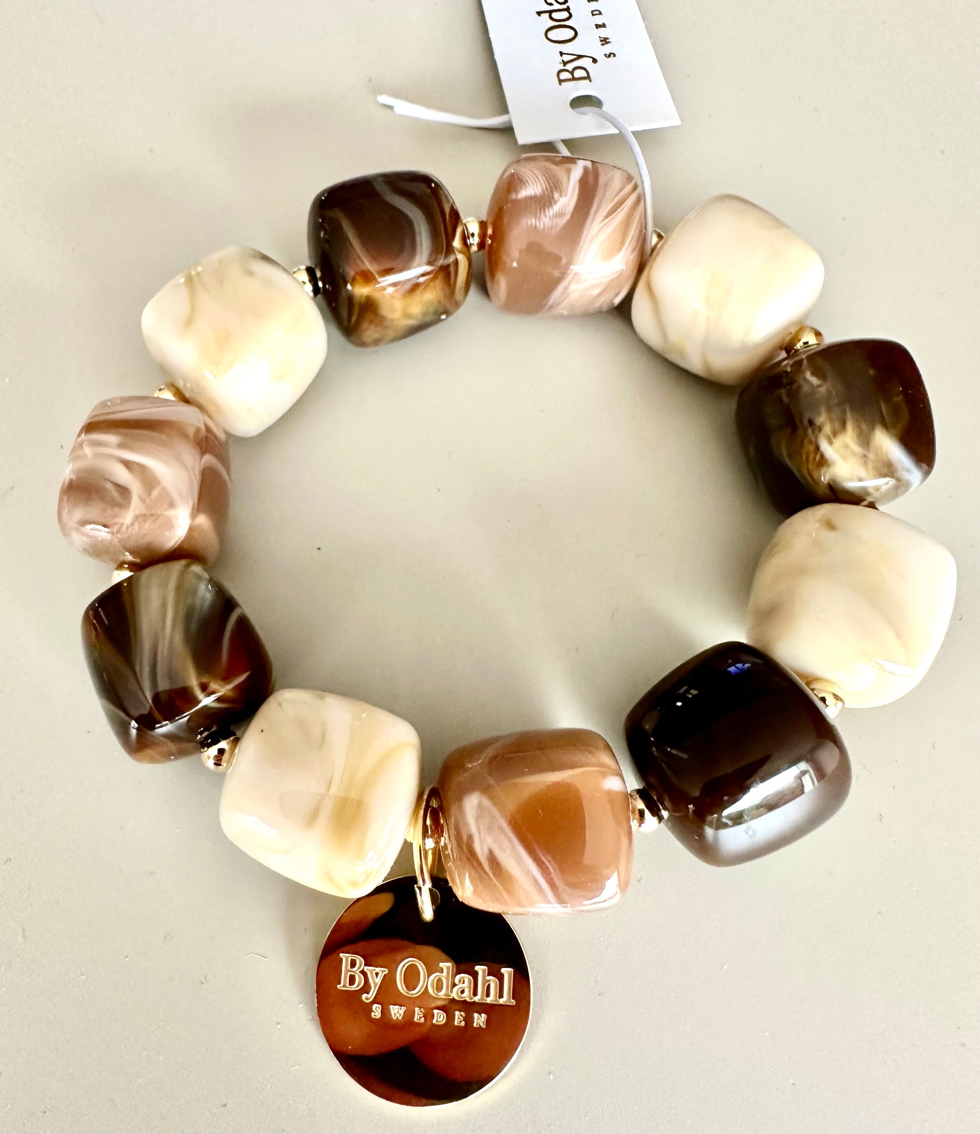 Armband med rundade pärlor i brun, beige och nougat med guldiga metalldetaljer, sett framifrån | By Odahl Sweden | Lilla Hem