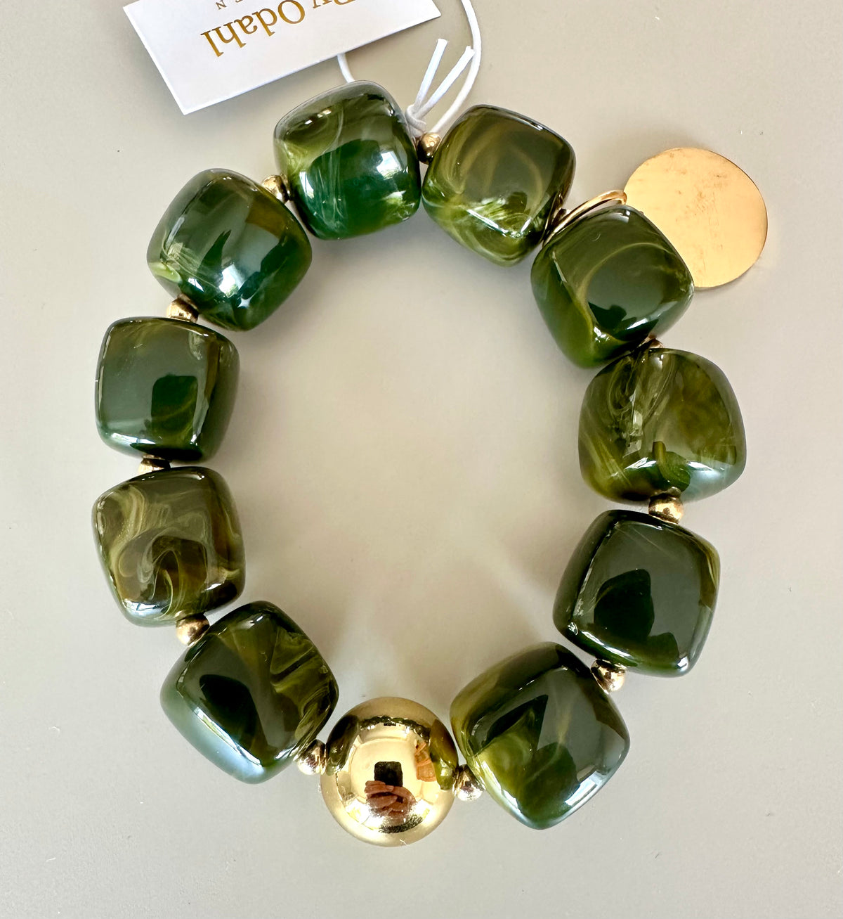 Armband med rundade glaspärlor i mossgrön och guldiga metallkulor, fotograferat ovanifrån | By Odahl Sweden | Lilla Hem