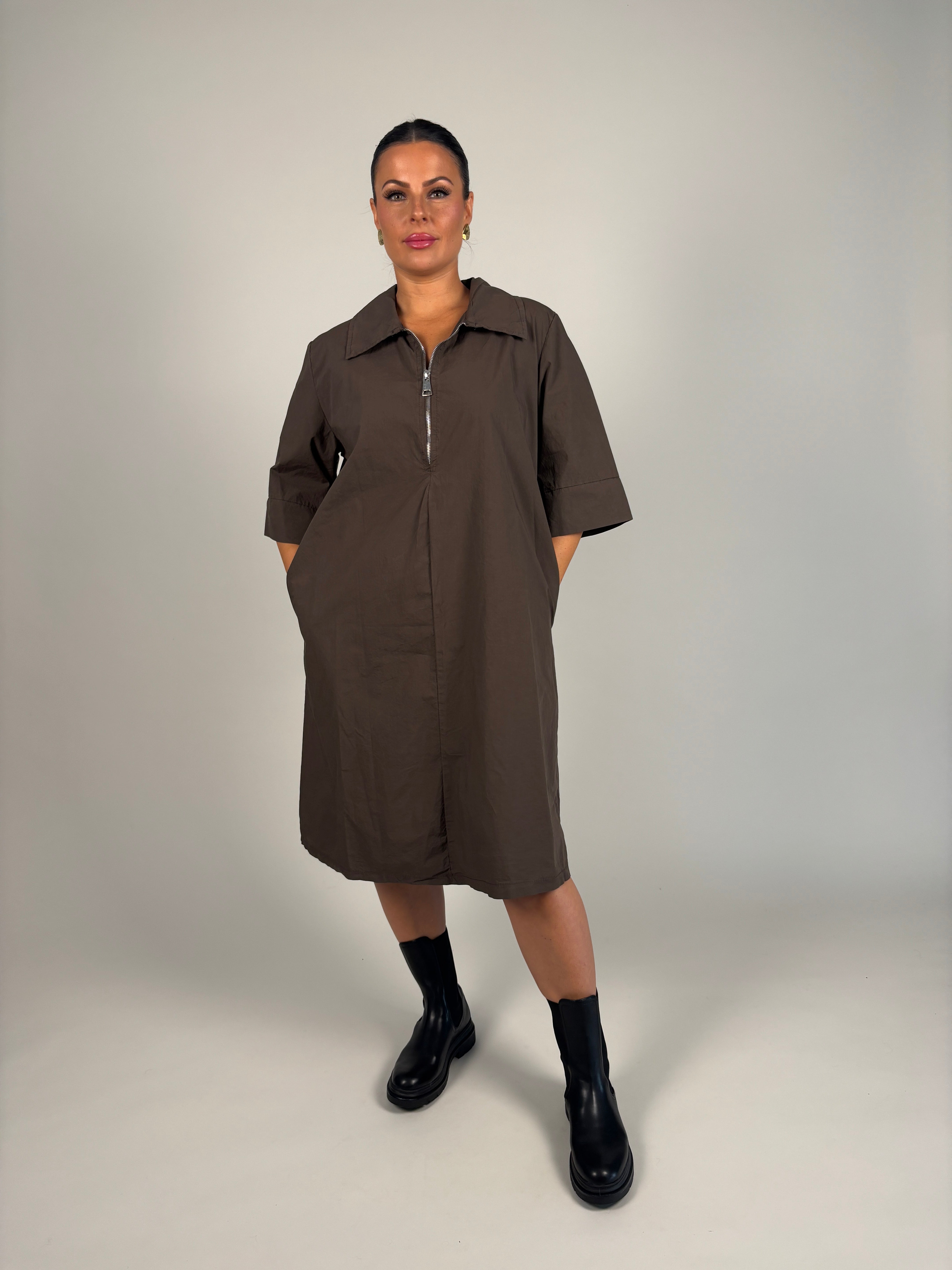 Modell bär brun skjortklänning med halv ärmad framsideslutsning, sett framifrån mot neutral bakgrund | Camicia | Lilla Hem