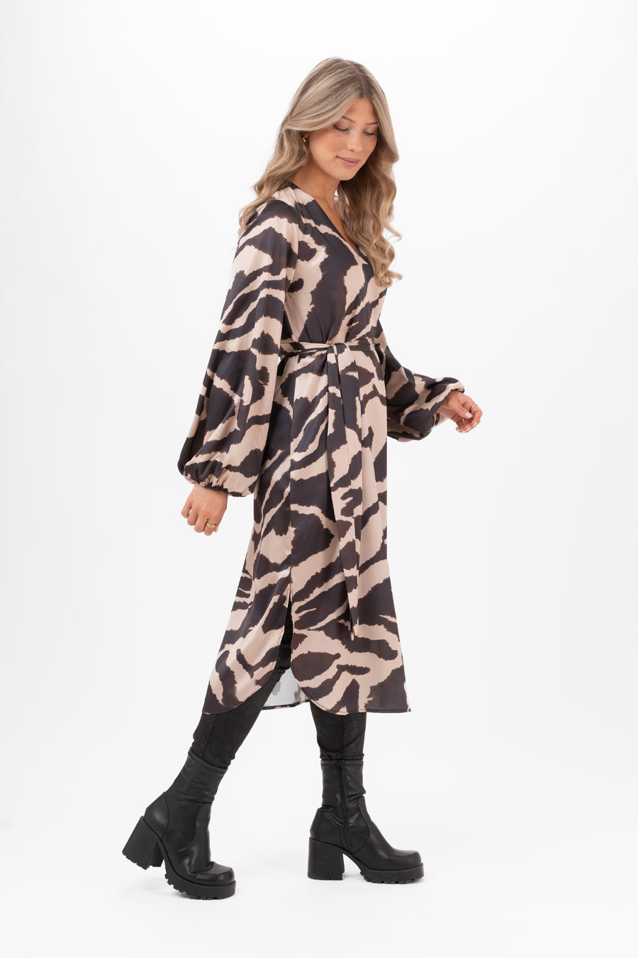 Modell bär skjortklänning med abstrakt tryck i svart och beige, sidovinkel med bälte och puffärmar | Capri Collection | Lilla Hem
