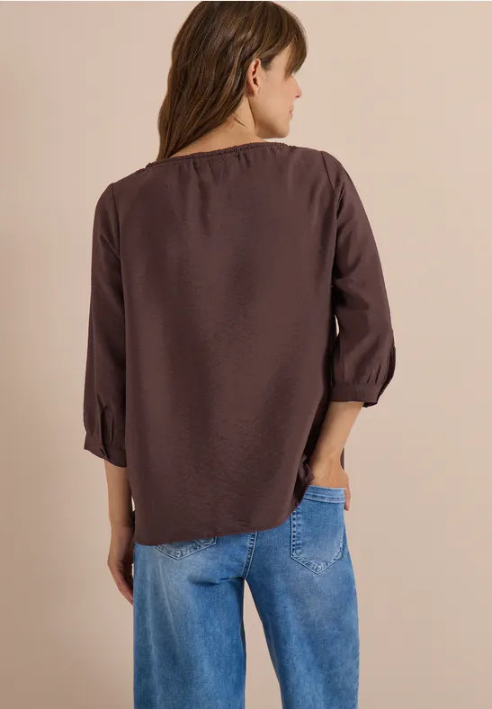 Modell bär brunröd blus sedd bakifrån, kombinerad med blå jeans | Cecil | Lilla Hem