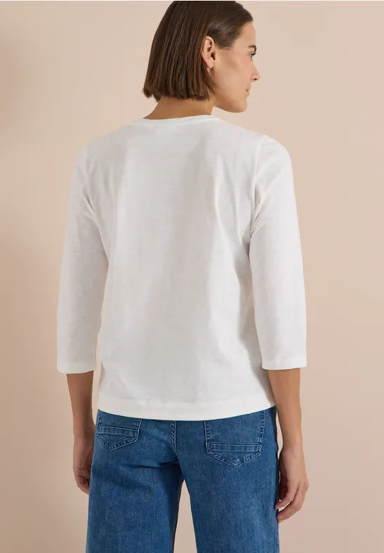 Modell bär vit tröja med trekvartslärm sedd bakifrån tillsammans med blå jeans | Cecil | Lilla Hem
