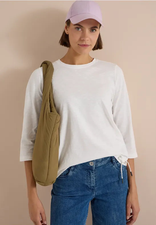 Modell bär vit långärmad t-shirt med blå jeans och olivgrön axelväska, sett framifrån | Cecil | Lilla Hem