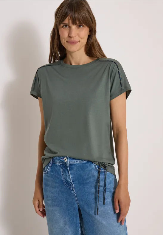 Modell bär grågrön t-shirt med kort ärm sett framifrån mot neutral bakgrund | Cecil | Lilla Hem
