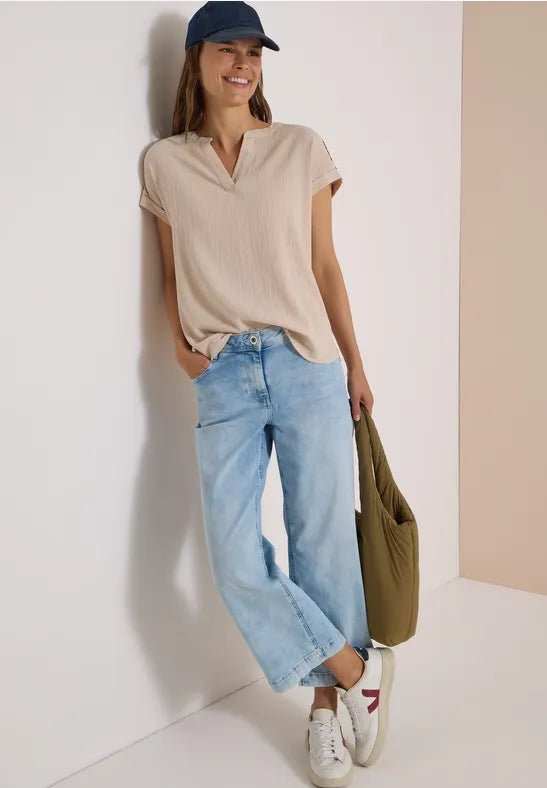 Modell bär beige blus med V-ringning och ljusblå jeans, sett framifrån | Cecil | Lilla Hem