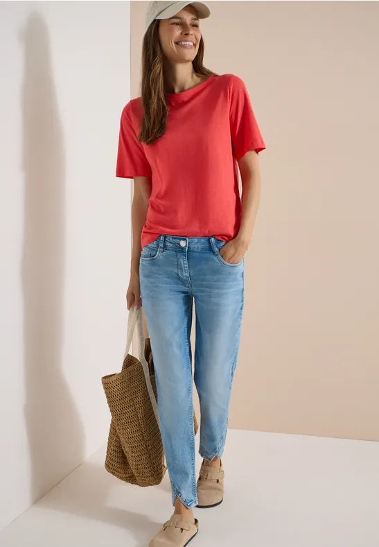 Modell bär röd t-shirt och ljusblå straight jeans sett framifrån med keps och väska | Cecil | Lilla Hem