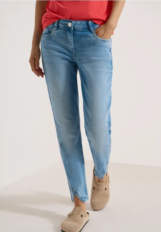 Modell bär ljusblå raka jeans med slitna kanter sett framifrån | Cecil | Lilla Hem