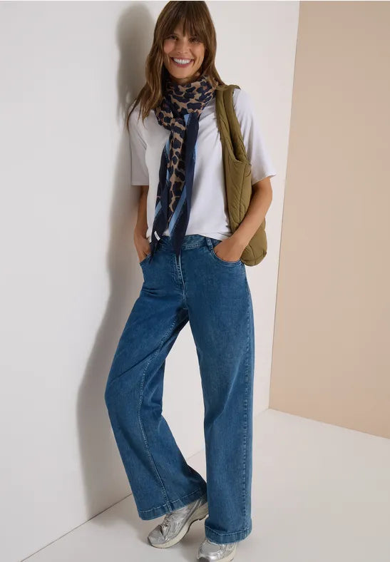 Modell bär vita t-shirt, khakiväst och vida blå jeans, accessoriserad med blåmönstrad scarf | Cecil | Lilla Hem