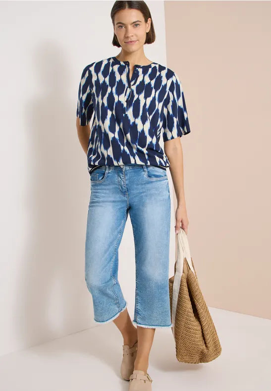 Modell bär mörkblå blus med vitt abstrakt mönster och ljusblå jeans, sett framifrån | Cecil | Lilla Hem