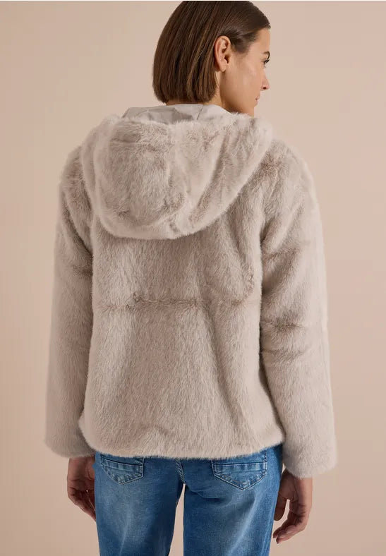 Modell bär pälsjackan sett bakifrån med huva och kombinerad med blå jeans | Cecil | Lilla Hem