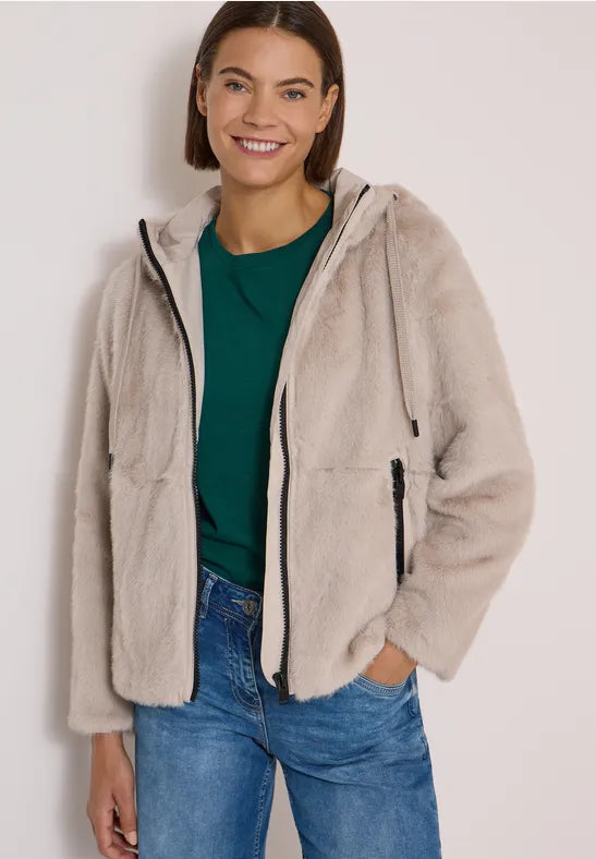 Modell bär beige fleecejacka med dragkedja framifrån över grön tröja och jeans | Cecil | Lilla Hem