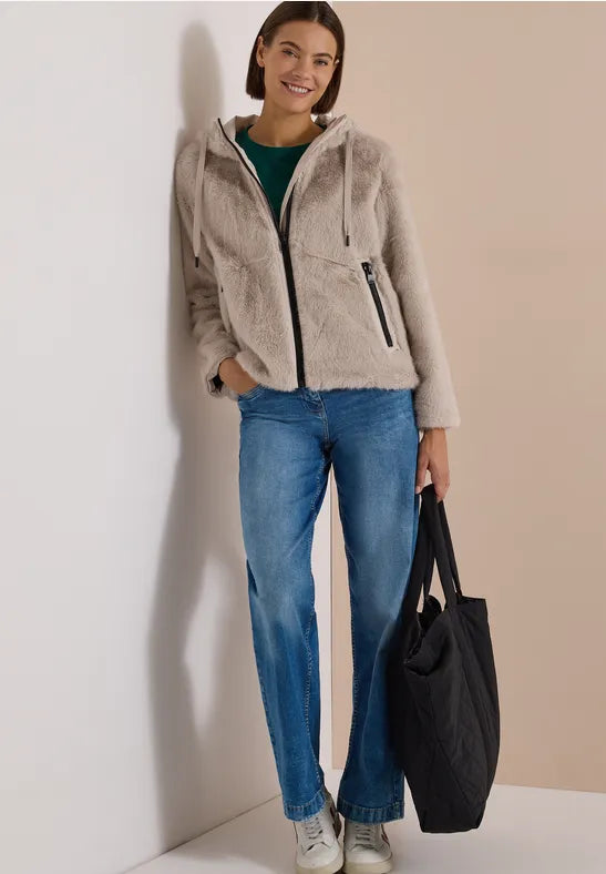 Modell bär beige fluffig jacka med huva och dragkedja framför blå jeans | Cecil | Lilla Hem
