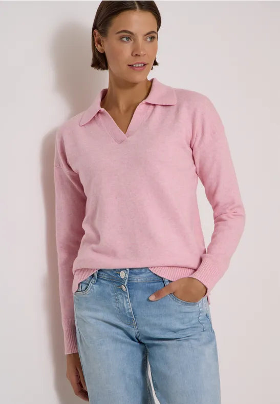 Modell bär rosa polotröja med v-ringning och blå jeans, fotograferad framifrån | Cecil | Lilla Hem