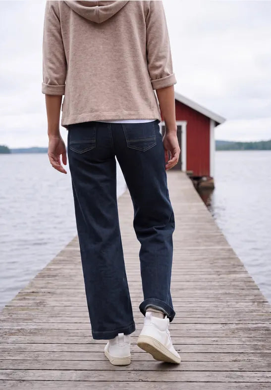 Modell bär mörkblå jeans sett bakifrån på brygga vid vatten | Cecil | Lilla Hem