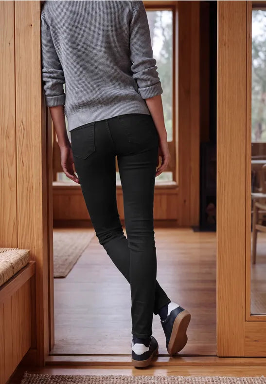 Modell bär grå ribbad tröja och svarta elastiska jeans, sett bakifrån i dörröppning | Cecil | Lilla Hem