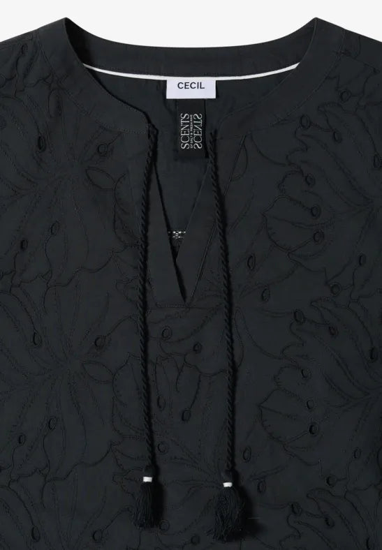 Närbild av svart klänning med blommig broderi och drawstring-snöre vid halsen | Cecil | Lilla Hem