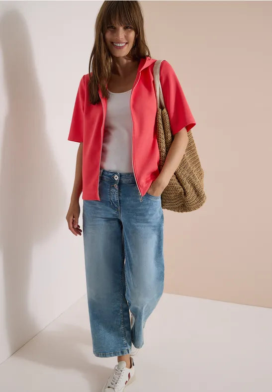 Modell bär rosa kortärmad skjorta över vit topp, blå jeans och brun väska, sett framifrån | Cecil | Lilla Hem