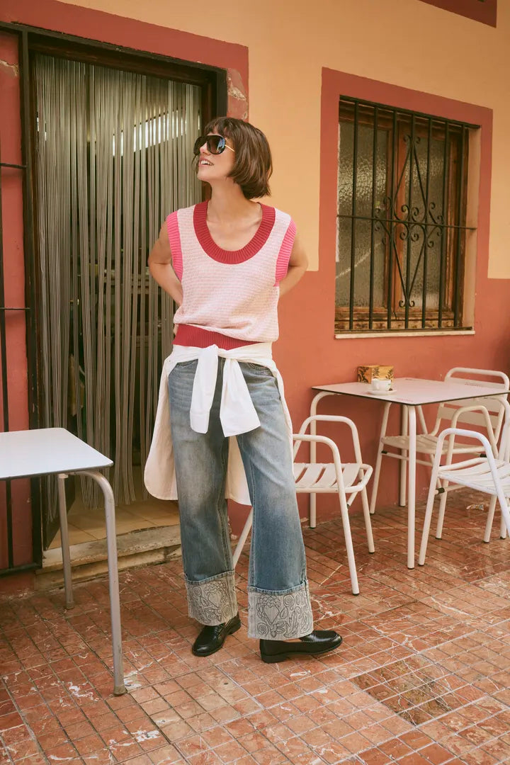 Modell bär rosa och vit ribbad väst över vita jeans med spetsdetaljer, sett framifrån | CULTURE | Lilla Hem