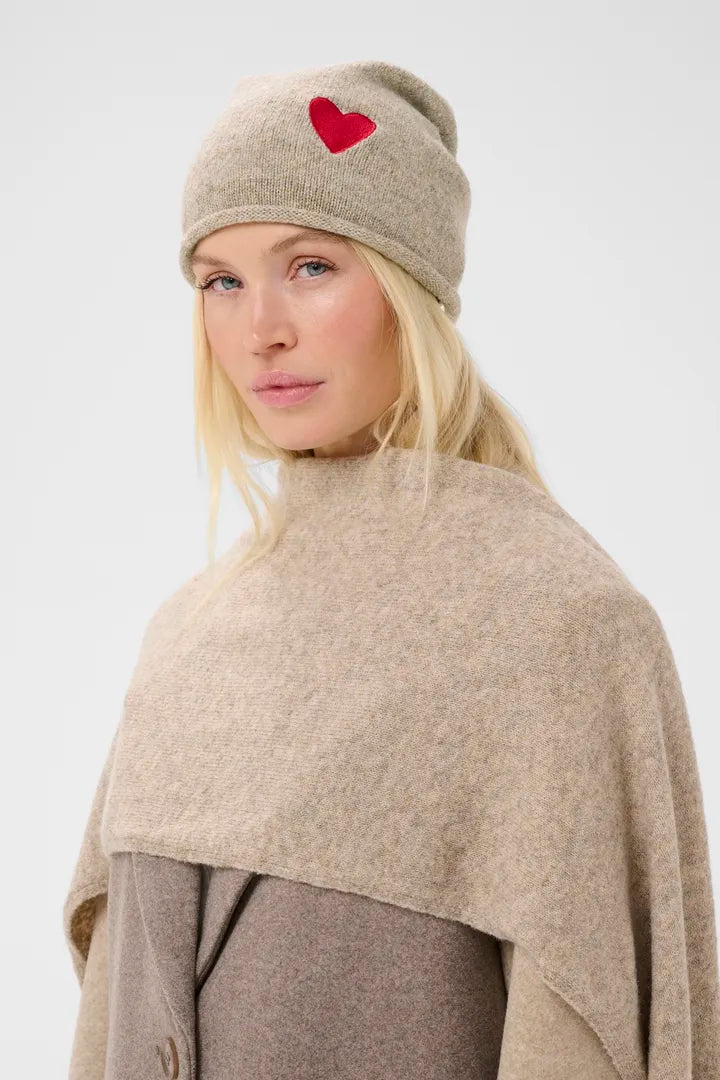 Modell bär beige mössa med rött hjärtmotiv, sett från sidan | CULTURE | Lilla Hem