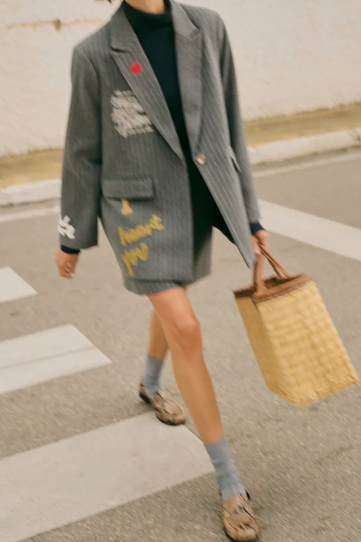 Modell bär grå oversized blazer med färgglada abstrakta tryck, sett framifrån i rörelse | CULTURE | Lilla Hem