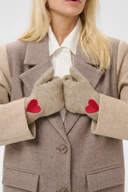 Modell bär beige handskar med röda hjärtdetaljer, visade framifrån tillsammans med beige blazer och vit skjorta | CULTURE | Lilla Hem