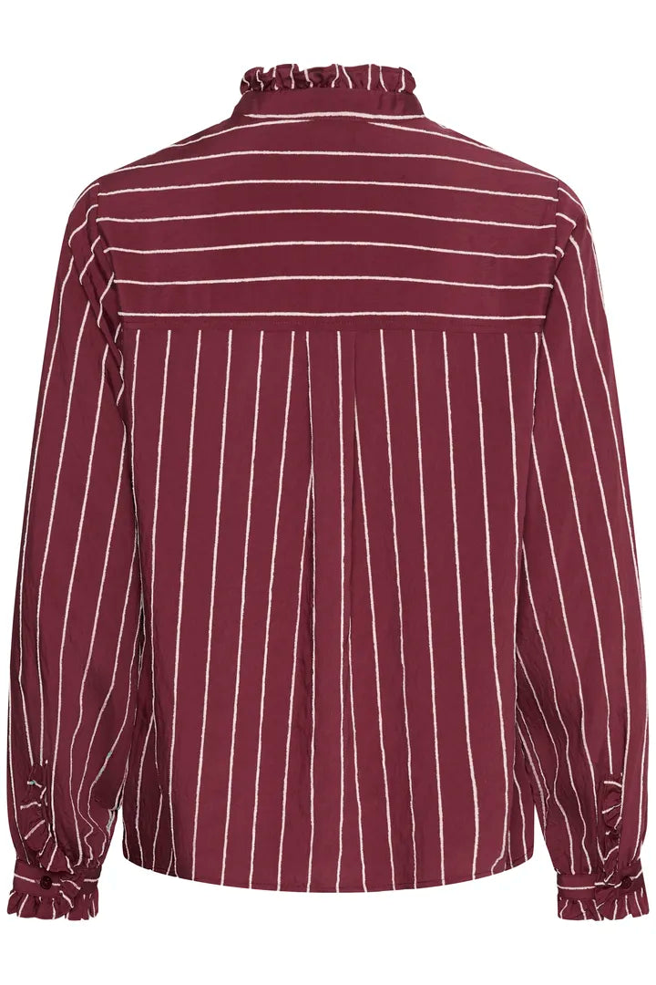 Burgundy blus med vita ränder sedd bakifrån, med volangkrage och volanger vid manschetterna | CULTURE | Lilla Hem