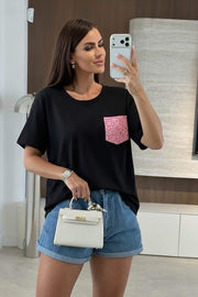 Modell bär svart t-shirt med rosa paljettficka, fotograferad framifrån i spegel | ISSYMA | Lilla Hem