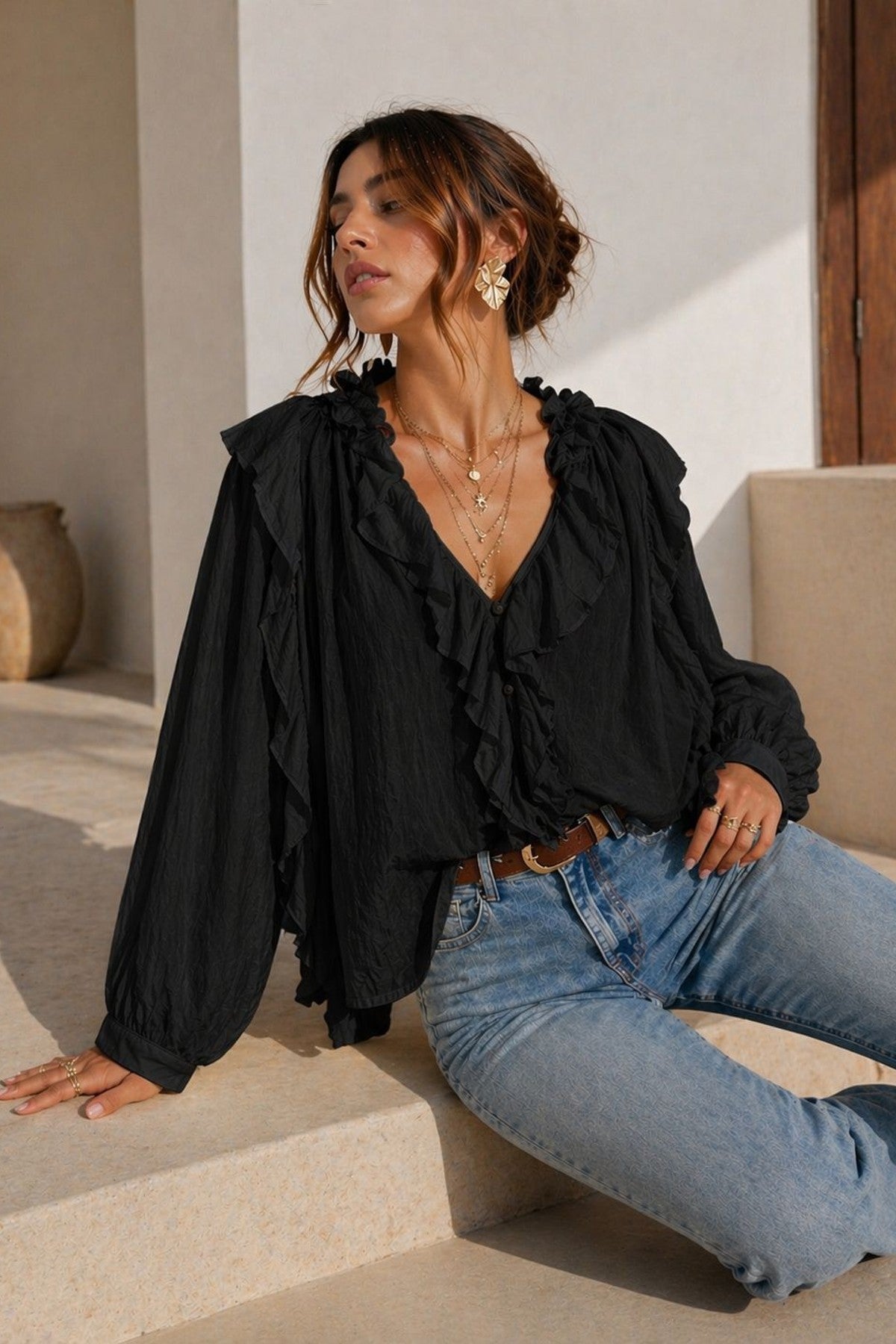 Modell bär svart volangblus med V-ringning och puffärmar, kombinerad med jeans | EMMA & ASHLEY DESIGN | Lilla Hem