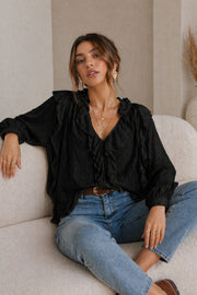 Modell bär svart volangblus med V-ringning och puffärmar, kombinerad med blå jeans | EMMA & ASHLEY DESIGN | Lilla Hem
