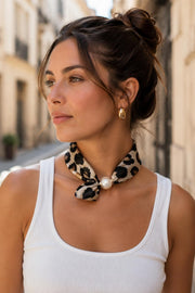 Modell bär leopardmönstrad scarf knutet runt halsen med pärldetalj, vit ribbad topp, sidoprofil | BEST ANGEL | Lilla Hem