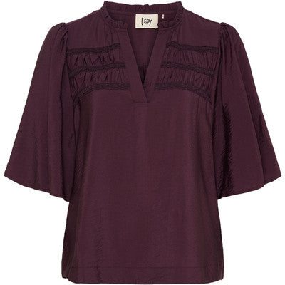 Burgundy blus med V-ringning och skrynklade detaljer på bröstet, fotograferad framifrån | I SAY | Lilla Hem