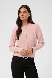 Modell bär rosa stickad kofta med knäppning framifrån, kombinerad med svarta jeans | KAFFE | Lilla Hem