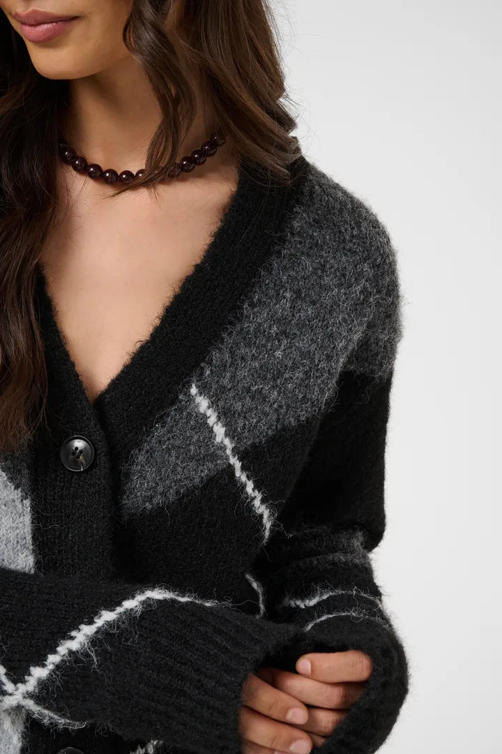 Modell bär cardigan med diagonala vita ränder, sett framifrån med närbild på krage och pärlemorknappar | KAFFE | Lilla Hem