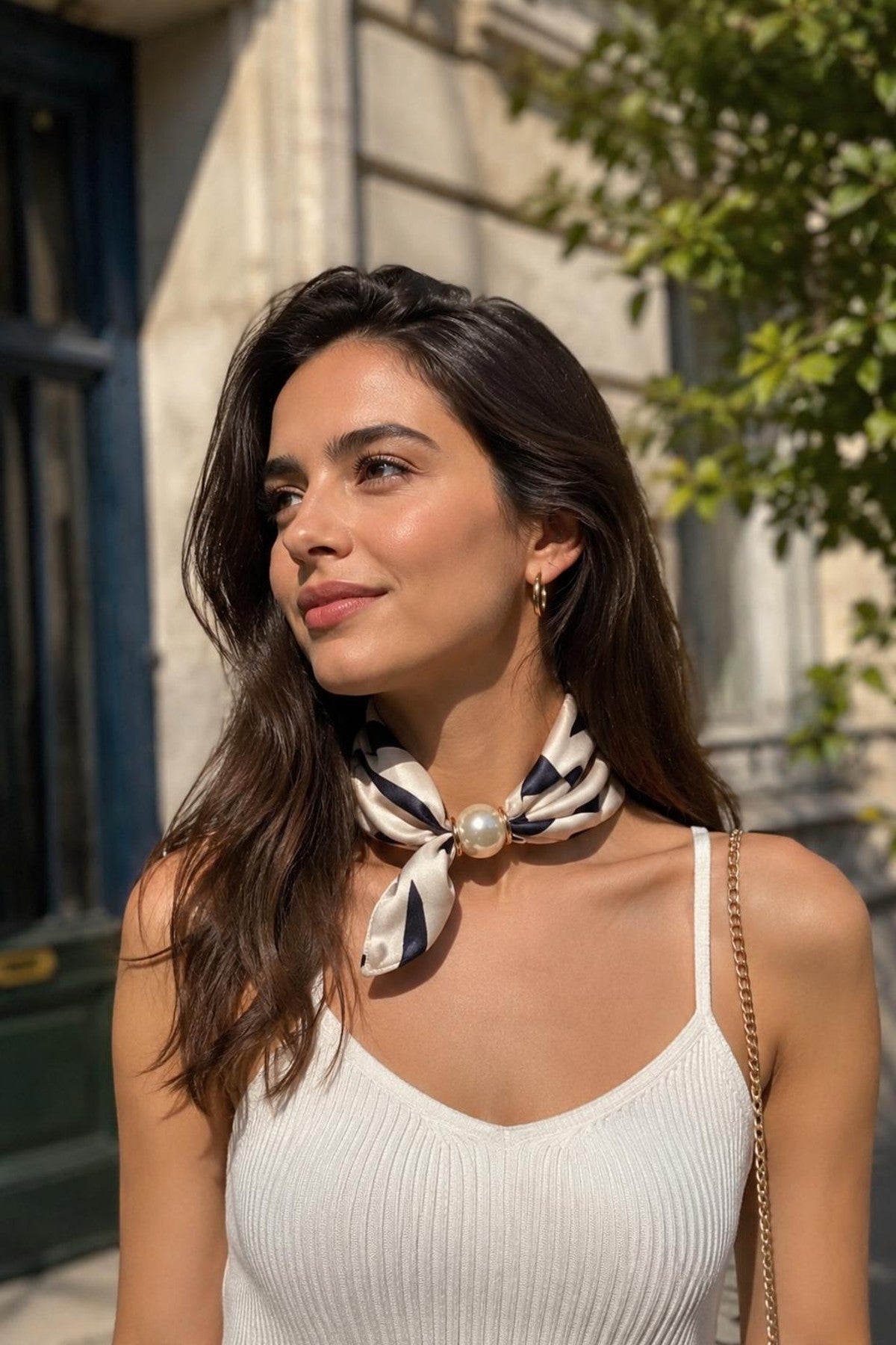 Modell bär scarf med pärla knuten runt halsen, sett från sidan mot stenvägg | BEST ANGEL | Lilla Hem