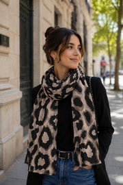Modell bär leopardmönstrad scarf i beige och svart, vikt runt halsen över svart tröja | BEST ANGEL | Lilla Hem