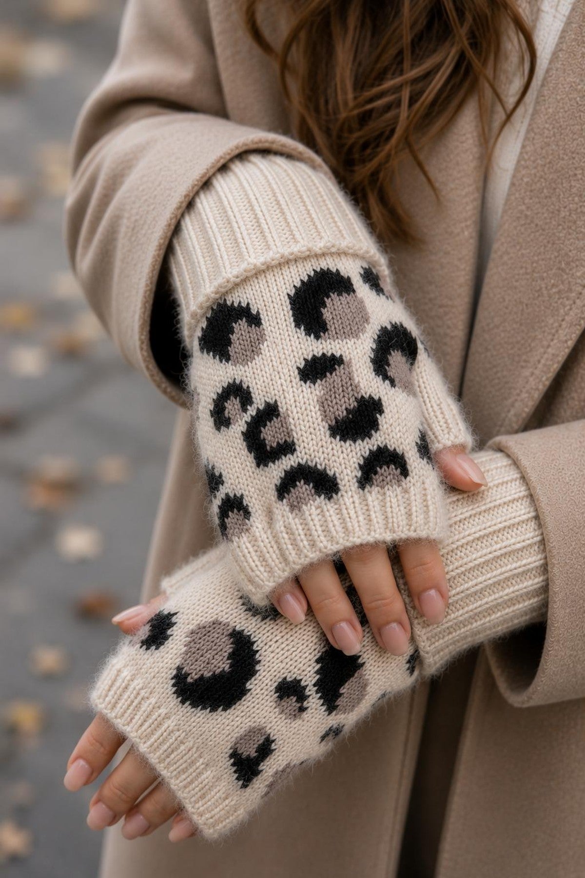 Närbild av beige handvärmare med leopardmönster i svart, buren av modell i beige kläder | BEST ANGEL | Lilla Hem