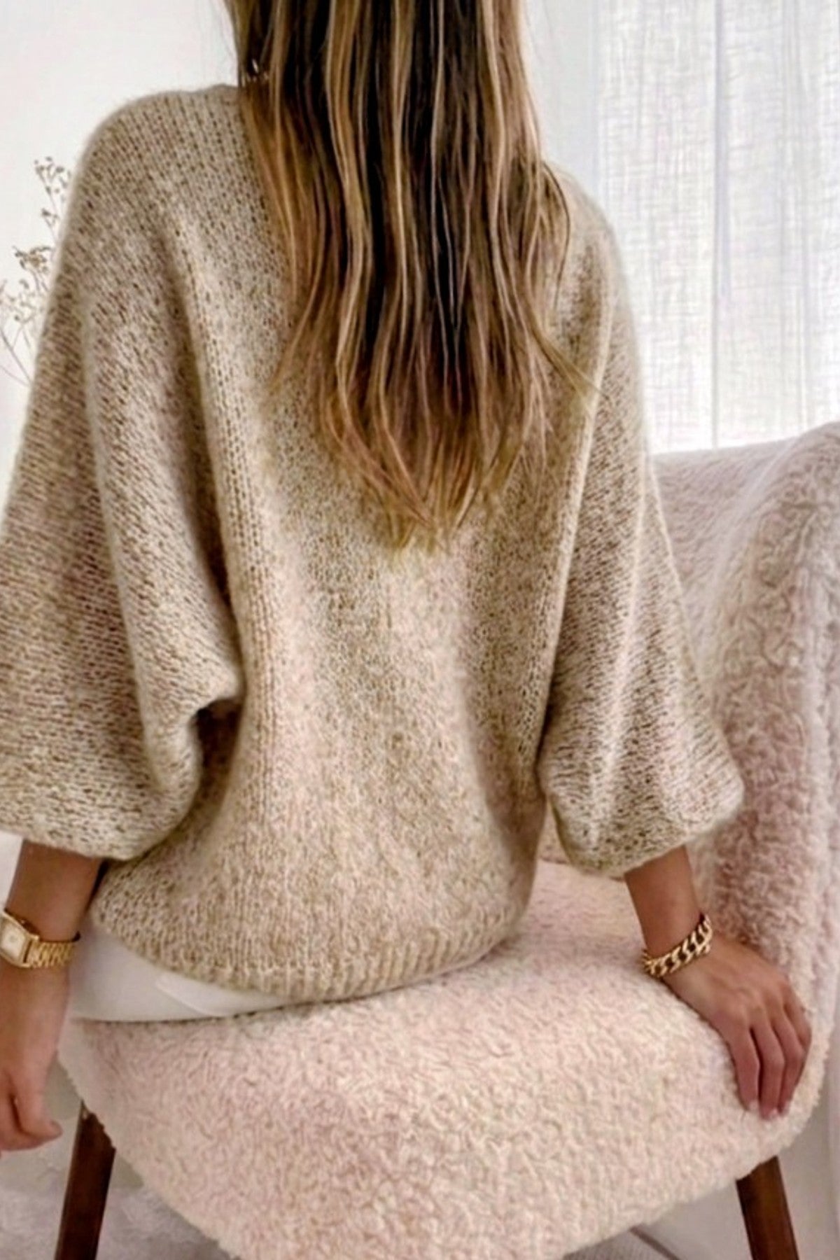 Modell bär beige stickad oversize-tröja sedd bakifrån, med vida ärmar och texturerad stickad struktur | RZ FASHION | Lilla Hem