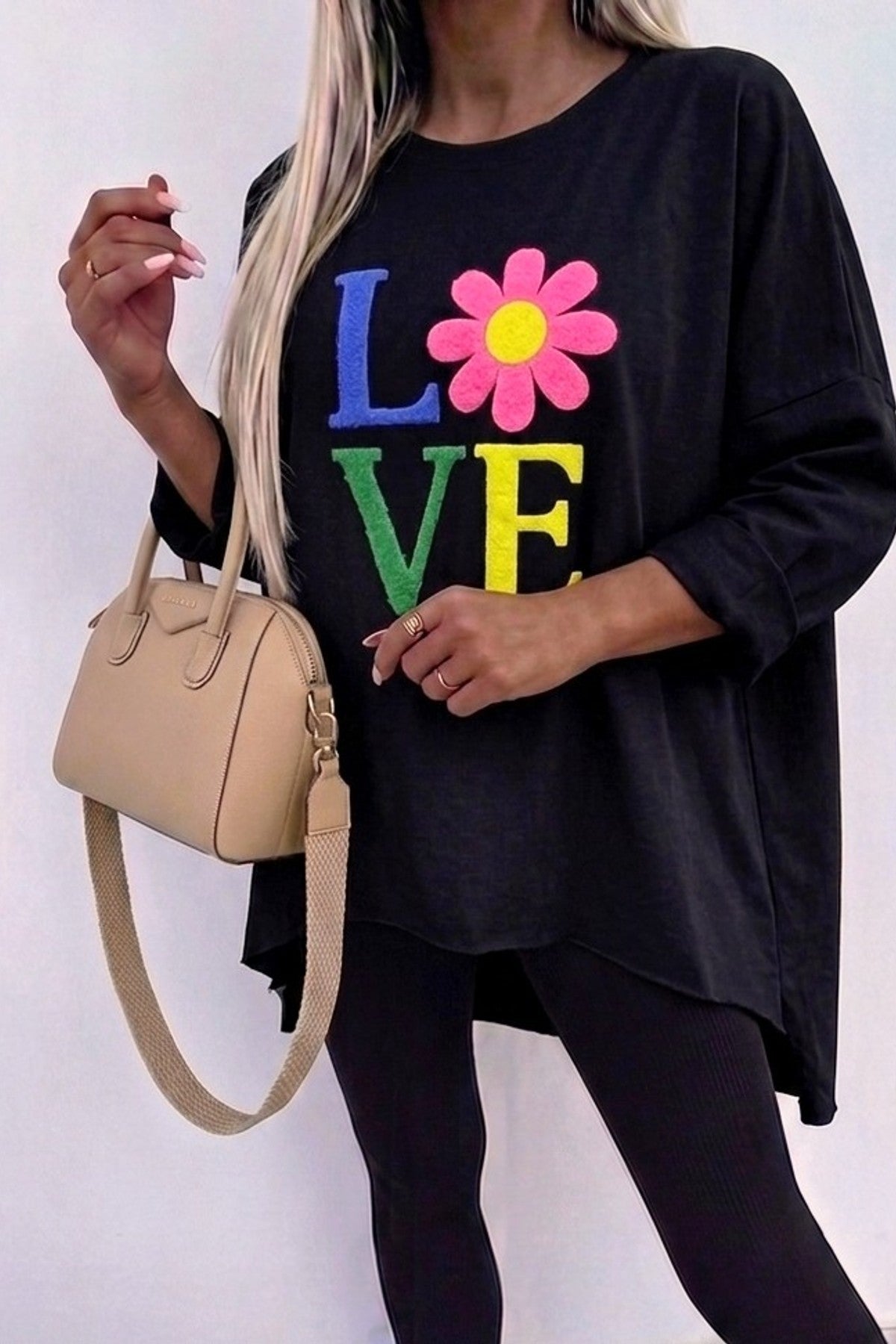 Modell bär svart sweatshirt med färgglatt "LOVE"-tryck och rosa blomma, sett framifrån | RZ FASHION | Lilla Hem