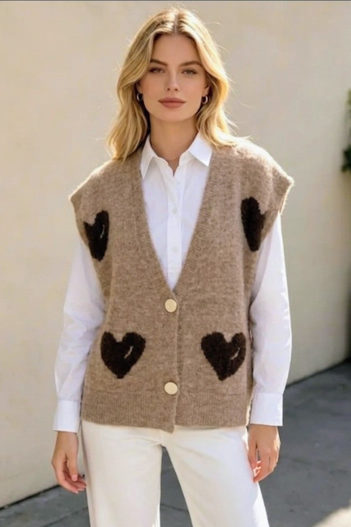 Modell bär beige stickväst med svarta hjärtmönster över vit skjorta, sett framifrån | RZ FASHION | Lilla Hem