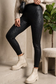 Modell bär svarta leopardmönstrade leggings med slitningar, kombinerat med beige stickad tröja och vita boots | QQ FASHION | Lilla Hem