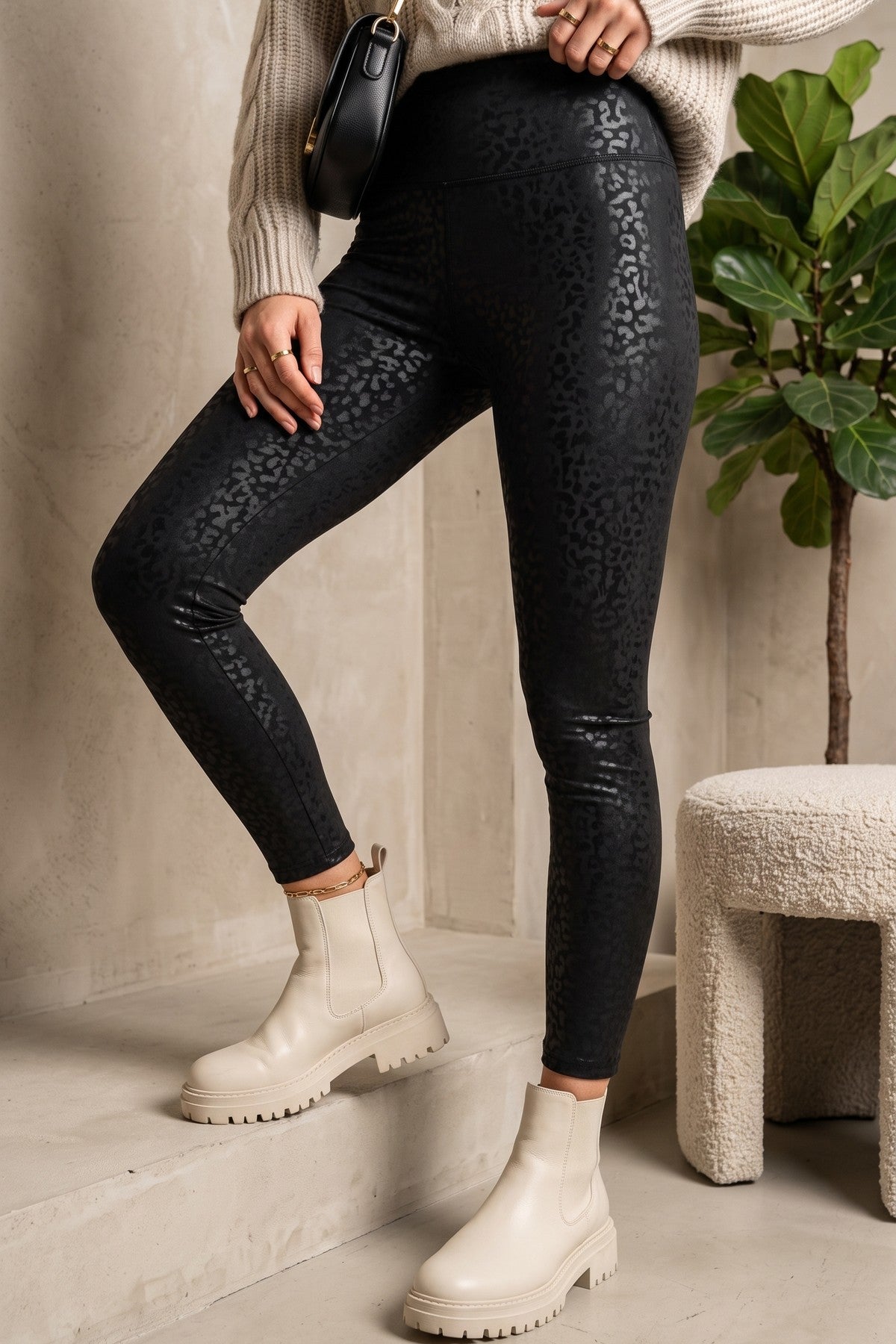 Modell bär svarta leopardmönstrade leggings med slitningar, kombinerat med beige stickad tröja och vita boots | QQ FASHION | Lilla Hem