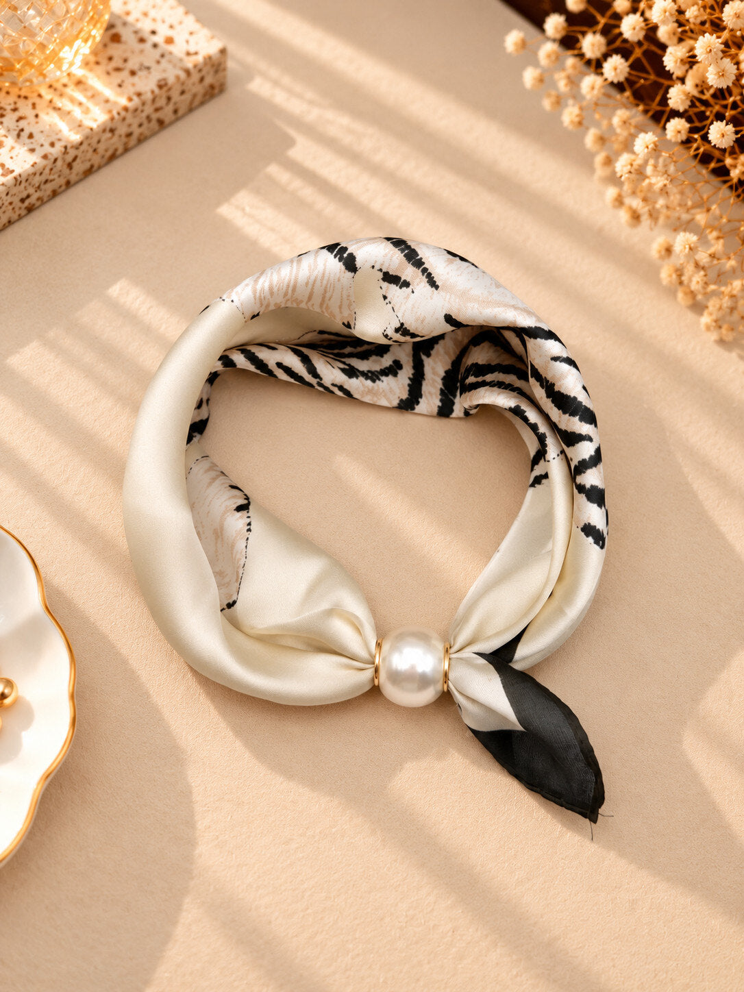 Scarf med zebramönster och pärldetalj, vikt i cirkel på beige bakgrund | CLAREN B | Lilla Hem