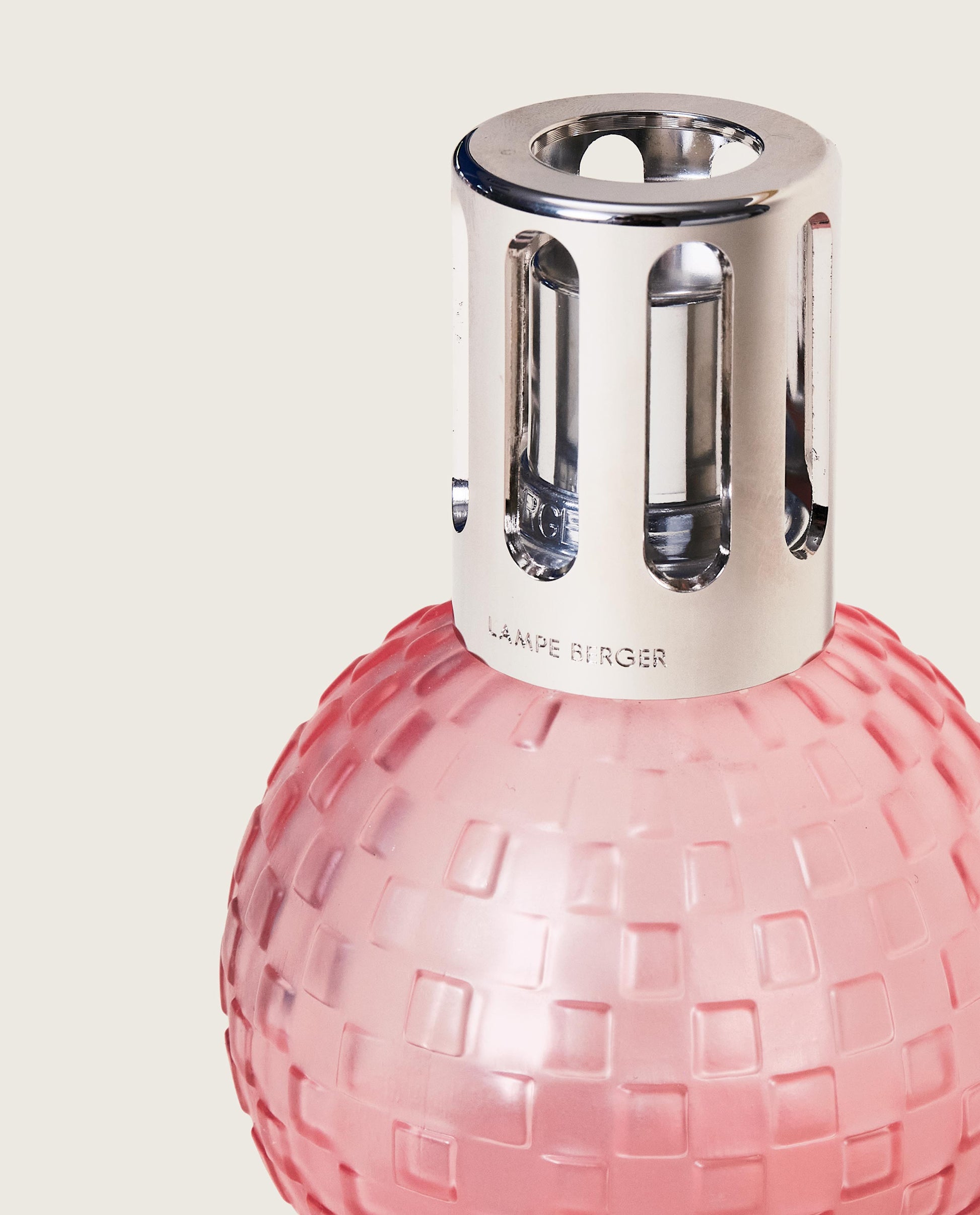 Närbild av rosa doftlampa med kvadratisk reliefmönster och silverfärgad metallöversta mot neutral bakgrund | Maison Berger | Lilla Hem