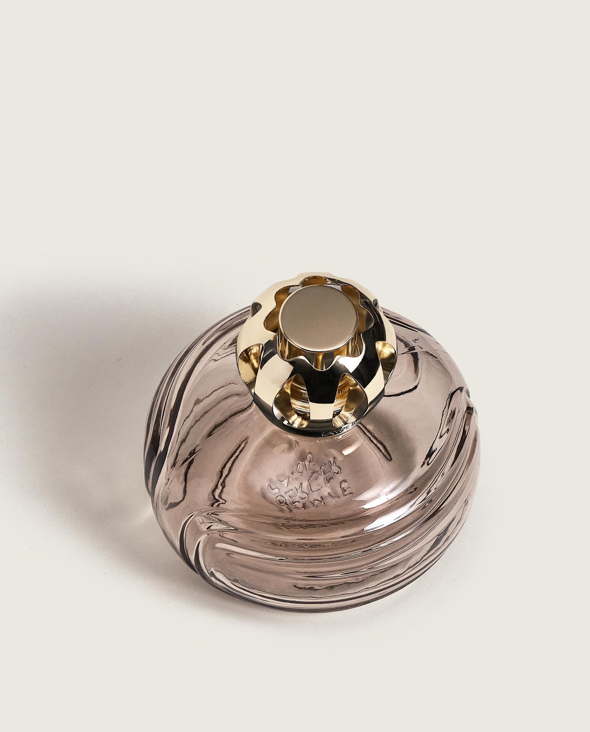 Rund doftlampa i rökfärgat glas med guldtonad metallkork, fotograferad från ovan mot vit bakgrund | Maison Berger | Lilla Hem